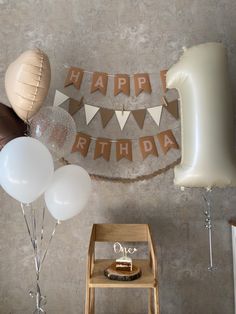 balloons and streamers are arranged on the wall for a birthday party with an arch