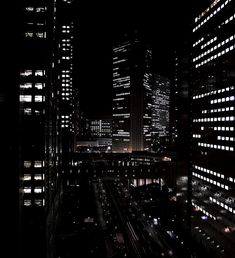 the city lights shine brightly at night in this black and white photo, as well as skyscrapers