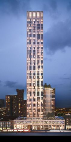 a very tall building sitting in the middle of a large city at night with lights on it