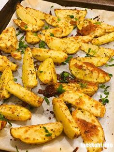 cooked potatoes with herbs and seasoning on a baking sheet, ready to be eaten