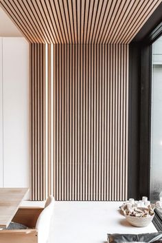 the interior of a modern home with wood slats on the wall and flooring