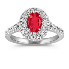 a red and white diamond ring on a white background with the center stone surrounded by diamonds