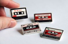 there are four small cassettes in the shape of magnets that look like old school tape recorders