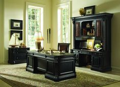 an office desk with two chairs and a bookcase