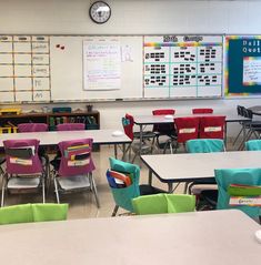 a classroom filled with lots of desks and chairs next to a wall mounted clock