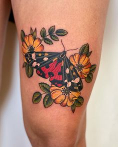 a small butterfly with flowers on it's thigh