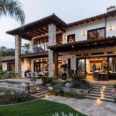 a large house with steps leading up to it's front door and patio area