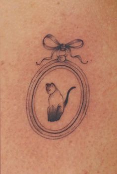 delicate tattoo of a siamese cat inside a frame with a bow on top <3 Siamese Tattoo Cat, Cat Collar Tattoo, Frame Tattoos For Women, Two Cats Tattoo Ideas, Cat Tattoo Dainty, Angel Kitten Tattoo, Framed Cat Tattoo, Cat Aesthetic Tattoo, Cat With Bow Tattoo