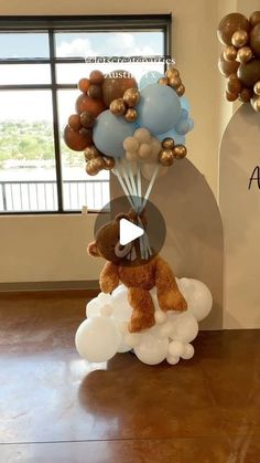 a teddy bear is on top of balloons in the shape of an air ballon