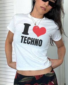 I Heart Techno Baby Tee Making a comeback being one of the most iconic trends of the '90s and early 2000's is the one and only baby tee. Make a nostalgic fashion statement by rocking this baby tee fit with whatever outfit you desire, picking a true to size fit will allow for a relaxed look or size down for that popular cropped fit, a perfect mixture of quality and comfort✨ About the product: 100% cotton for solid colour print Fit with a crew neckline for a timeless fashionable look Tear-away lab Fitted T-shirt With Heart Graphic For Streetwear, Grunge Crew Neck Top With Heart Graphic, Graphic Tee With Heart Graphic For Streetwear, Y2k White Graphic Top, Y2k White Graphic Design Top, White Y2k Graphic Design Tops, White Graphic Design Y2k Top, 90s Inspired White Graphic T-shirt, White Slogan Tops In Grunge Style