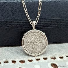 This vintage Elizabeth II English Sixpence rests in a handcrafted setting made of recycled sterling silver wire. I make each setting by hand separately from the coin. The coin does not have a hole drilled in it or any metal soldered to its edge. The handmade setting is sturdy and allows the coin to be worn as a charm on a bracelet. The setting is stamped with both my maker's and metal purity (925) mark on the bail's interior. The obverse of the coin features a portrait of Elizabeth II by Mary Gi Silver Coin Pendant Necklace, Vintage Jewelry Display, Silver Coin Necklace, Custom Coins, Mens Silver Jewelry, Tudor Rose, Silver Link Chain, Gold Jewelry Stores, Coin Jewelry