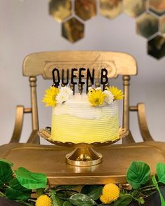 a cake sitting on top of a table next to a chair and flowers in front of it