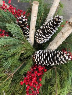 pine cones and berries are arranged in a wreath