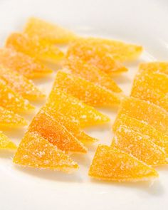 orange slices are arranged in rows on a white plate, ready to be cut into wedges