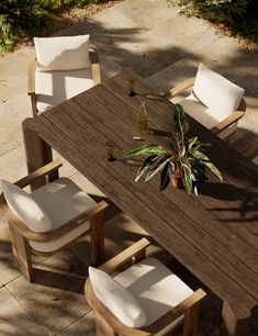 an outdoor table with chairs and a potted plant