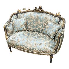 an ornately decorated couch with blue and gold fabric on the back, sitting against a white background