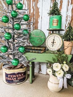 a green christmas tree sitting on top of a table next to a potted plant