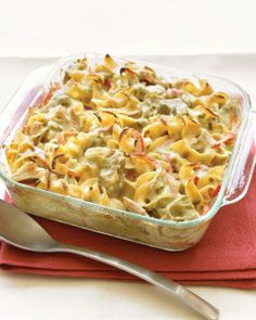 a casserole dish with pasta and vegetables in it on a red place mat