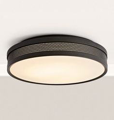 a black circular light fixture hanging from the ceiling