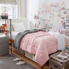 a bed room with a neatly made bed and pink comforter on top of it