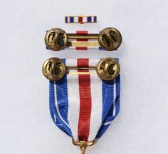 two medals are placed next to each other on a white surface with gold trimmings