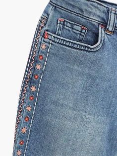 a pair of blue jeans with embroidered details