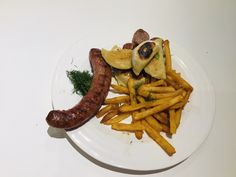 a white plate topped with french fries and a sausage