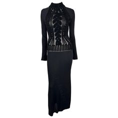 Presenting a stunning black knit Thierry Mugler long-sleeve gown, designed by Manfred Mugler. From the Mid-1990s, this knit bodycon dress features a mock neck and stands out with a sheer torso with a scrolling velvet devoré pattern creating a faux cable knit effect. The sheer torso adds the perfect seductive touch to this form-fitting stretch maxi dress. Chic and sexy, this vintage Thierry Mugler dress is the perfect addition to any wardrobe! Approximate measurements: Size - L Bust: 30 - 40" Waist: 24 - 30" Hips: 33 - 44" Shoulder to Hem: 60" Shoulder to cuff: 21" Armpit to cuff: 20" 88% Viscose, 12% Woolreal Thierry Mugler Dresses, Thierry Mugler Dress, Mugler Dress, Vintage Thierry Mugler, Bodycon Gown, Knit Bodycon Dress, Sleeve Gown, Long Sleeve Gown, Knitted Bodycon Dress