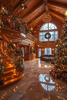 a large christmas tree sitting in the middle of a living room next to a staircase