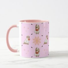 a pink coffee mug with dogs and spider webs on it