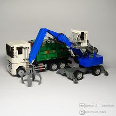 there is a toy truck with a crane attached to it's back and two smaller trucks behind it