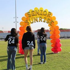 some girls are standing in front of an arch that says senior sunrise with balloons on it