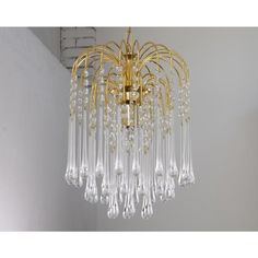 a chandelier hanging from the ceiling with clear glass drops and gold trimmings