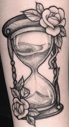 a tattoo with an hourglass and roses on it