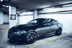 a black car parked in a parking garage