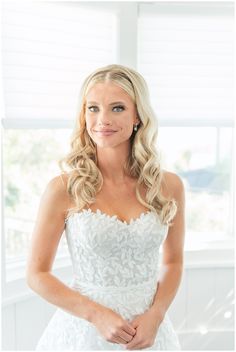 a woman in a wedding dress posing for the camera with her hands on her hips