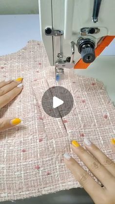 two hands are using a sewing machine to sew on the fabric with yellow and white nails