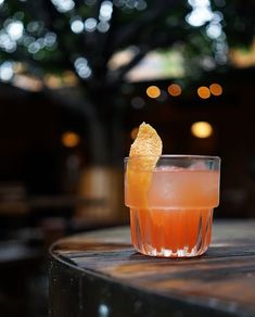 an orange drink sitting on top of a wooden table