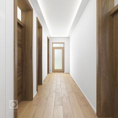 an empty hallway with wooden doors and white walls