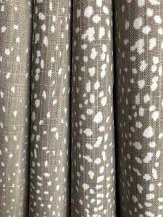 the curtains are lined up and ready to be used in this project, with white spots on grey fabric