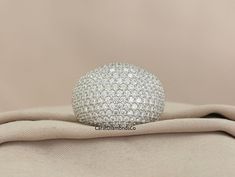 a white diamond ring sitting on top of a cloth