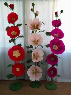 paper flowers are lined up in front of a window