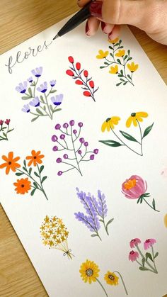 someone is drawing flowers on a piece of paper with watercolor pencils and ink