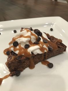 a piece of cake with chocolate chips and ice cream on top is sitting on a white plate