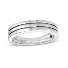 a white gold ring with two blue sapphire stones on the side and one diamond in the middle