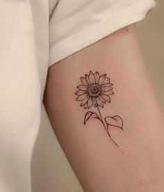 a small sunflower tattoo on the arm