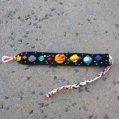 a black beaded lanyard with an image of the planets and stars on it