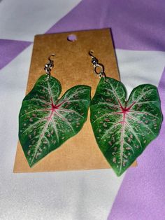 This pair of caladium leaf earrings is the perfect gift for the plant lover in your life! They are semi-transparent, made of a proprietary polymer, are lightweight and the handmade design is visible from both sides.  They are NOT waterproof, please do not wear these to shower or swim (fine in rain). From start to finish, each earring is designed and made by hand by yours truly with the upmost care. Trendy Handmade Leaf-shaped Earrings, Leaf-shaped Earrings For Summer, Handmade Adjustable Leaf-shaped Earrings, Handmade Leaf-shaped Nature-inspired Earrings, Handmade Leaf-shaped Botanical Earrings, Fabric Earrings, Semi Transparent, Jacksonville Fl, Yours Truly