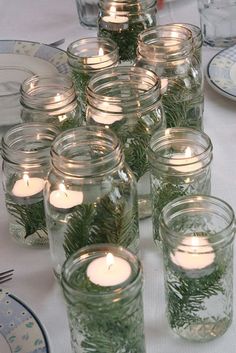 several mason jars filled with candles on top of a table