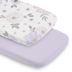 two baby mattresses with flowers on them, one is purple and the other is white